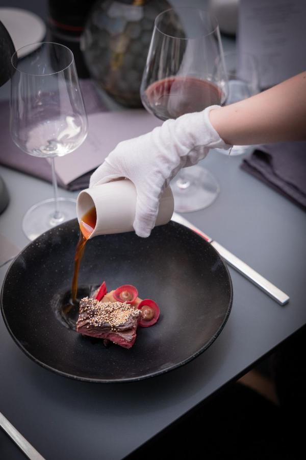 Hotel Maximilian'S アウグスブルク エクステリア 写真 A chef pouring a sauce